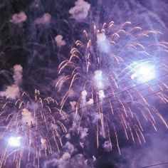 fireworks are lit up in the night sky above power lines and telephone poles with lights on them