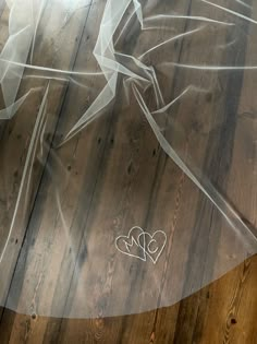 a bride's veil and shoes on a wooden floor with the word love written in it