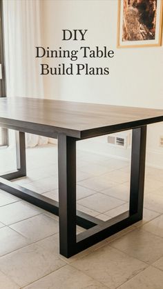 a wooden table sitting on top of a white tiled floor next to a wall with pictures above it