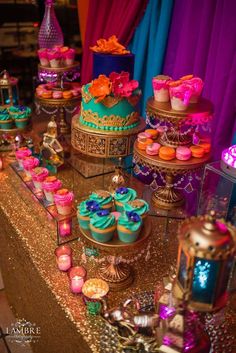 a table topped with lots of cakes and cupcakes on top of it's sides