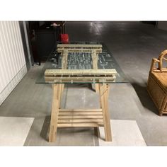 a table made out of wood and glass in a room with two baskets on the floor