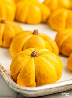 small yellow pumpkins sitting on top of a white tray