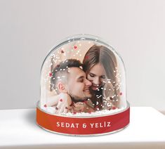 a personalized photo under a glass dome with red ribbon and hearts on the bottom