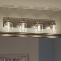 a bathroom vanity light with mason jars on it