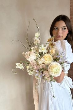 a woman holding a bouquet of flowers in her hands