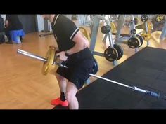 a man is squatting down with a barbell