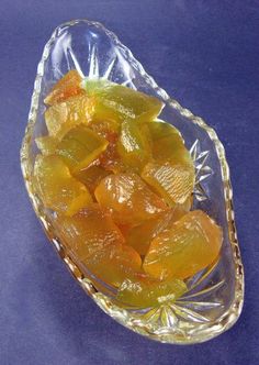 a glass bowl filled with orange peels on top of a blue table