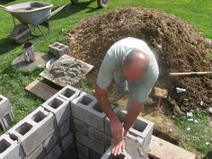 a man is placing bricks in the ground