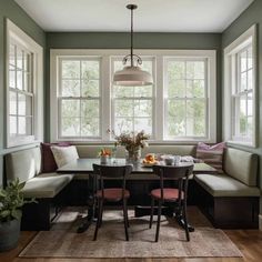 a dining room table with two benches and a bench in front of the bay window