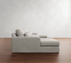 a couch sitting on top of a wooden floor next to a white wall and wood floor