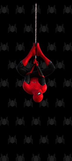 a spider man hanging upside down on a rope in front of a black and red background