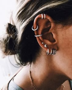 a close up of a person with ear piercings on their ears and behind the ear