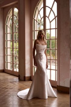 a woman in a white wedding dress posing for the camera