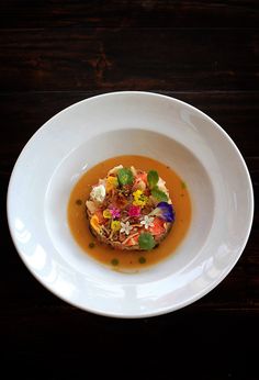 a white bowl filled with food on top of a wooden table