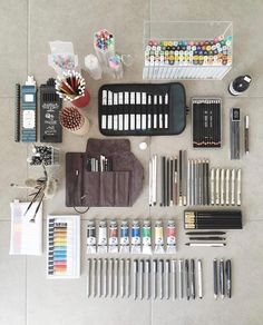 an assortment of art supplies laid out on the floor with markers, pencils and pens