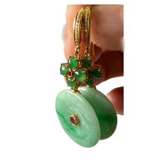 These stunning 18k gold art deco earrings showcase a large 100% round jadeite jade stone accented by centered ruby stone . Four additional round jade stones create a floral design, with a centered ruby and pave diamond on top. Measuring 2" in height and 1" in width, with a depth of 0.50", these earrings exude sophistication and elegance. Elegant Multi-stone Round Earrings, Yellow Gold Jade Earrings, Fine Jewelry Jade With 17 Jewels, Yellow Gold Pierced Jade Jewelry, Round Jade Jewelry With Matching Earrings, Luxury Round Earrings With Natural Stones, Luxury Earrings With Natural Stones, Exquisite Green Jade Jewelry, Formal Round Jade Jewelry