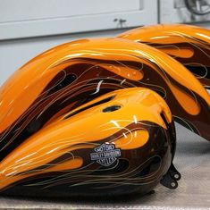 two orange motorcycle helmets sitting on top of a table