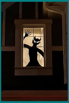 the silhouette of a person is seen through a window in a dark room with white trim