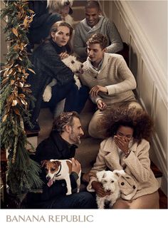 a group of people sitting on the stairs with their dogs and one man holding a dog