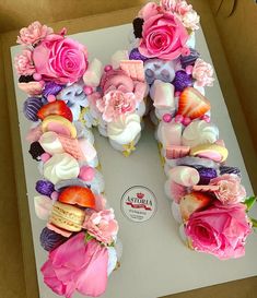 the letter n is made out of cupcakes and flowers on top of a box