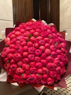 a large bouquet of red flowers sitting on top of a table