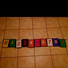 the numbers are arranged in rows on the tiled floor, which is also spelled with magnets