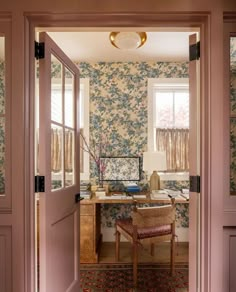 an open door leading to a room with floral wallpaper on the walls and floor