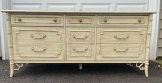 an old dresser is painted white with bamboo handles