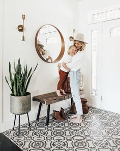 two women are standing in front of a mirror, one is holding the other's leg