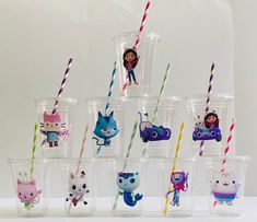 there are many plastic cups with different animals in them and one is filled with drinking straws