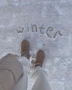 someone is standing in the snow with their feet up and writing on the ground that says winter