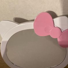 a hello kitty mirror with a pink bow on it