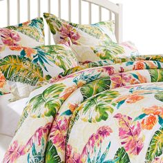 an image of a bed with colorful flowers on the comforter and pillowcases