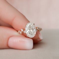 a woman's hand holding an engagement ring with a large diamond in the middle