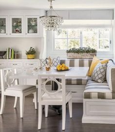 a dining room table and bench in front of a window