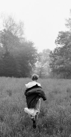 black and white photograph of a person running through a field