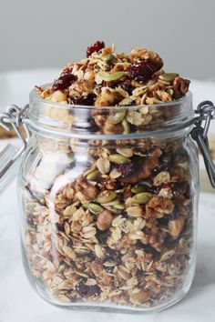 a glass jar filled with granola and nuts