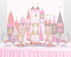 a table topped with cake and desserts on top of a pink cloth covered table