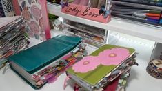 many different types of crafting supplies are on display in a store shelf, including notebooks and magazines