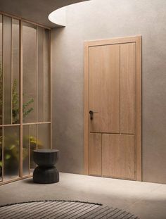 a wooden door sitting next to a window in a room with a rug on the floor