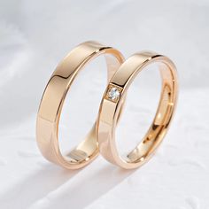 two gold wedding rings with diamonds on them