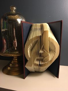 an origami sculpture sitting on top of a table next to a clochet