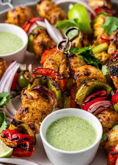 chicken kebabs with green dipping sauce on the side and garnished with cilantro