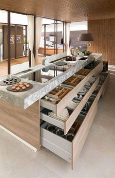 an open kitchen with lots of drawers and counter space in the center, along with food on plates