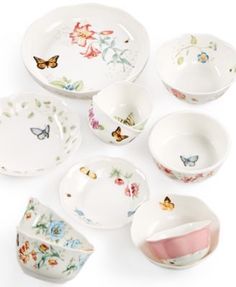 a collection of porcelain dishes, cups and saucers with butterflies on the rims