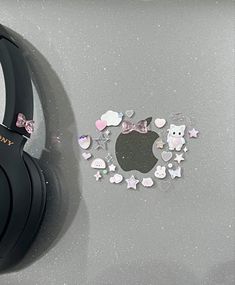 a pair of black headphones sitting on top of a gray surface with pink and white stars