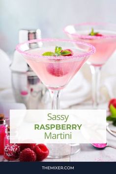 two glasses filled with raspberry martini on top of a table