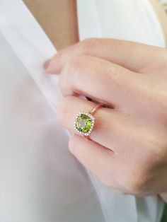 "A round Peridot surrounded by 24 diamonds in a cushion shape halo. A really distinctive luxury ring, the perfect choice for an engagement ring. Item Details ❤ Made to Order ✔ Available Gold Color: Rose Gold, Yellow Gold, White Gold ✔ Number of Blue Topaz: 1, Diameter approx 8mm, total CTW approx:1.85 Ctw ✔ Number of Diamonds: 24, total CTW: 0.17 Ctw ✔ Diamond Color-Clarity: G Color, VS Clarity ✔ Width approx: 10mm x10mm ✔ Height on top: 5.2mm ✔ The band details: Width: 1.70mm Thickness: 1.60mm Green Cushion Cut Diamond Ring With Center Stone, Green Cushion Cut Diamond Ring, Lime Green Diamond Ring With Gemstone, Green Cushion Cut Diamond Jewelry, Lime Green Diamond Gemstone Rings, Green Cushion Cut Jewelry With Halo Setting, Green Cushion Cut Halo Setting Jewelry, Peridot Rings With Halo Setting For May Birthstone, Green Cushion Cut Diamond Ring For Anniversary