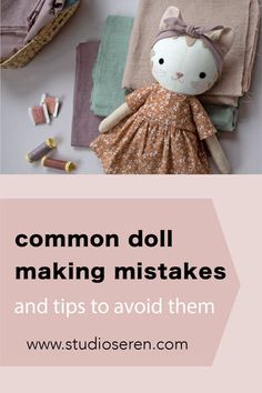 a stuffed animal sitting on top of a table next to some cloths and sewing needles