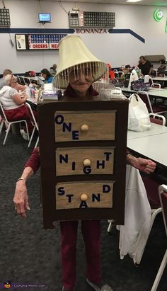 a person wearing a costume made to look like an old woman holding a drawer with letters on it